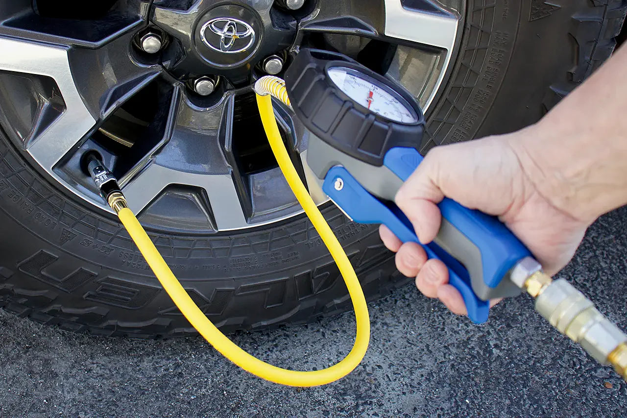 Person using an Analogue Tyre inflator to check or adjust the pressure of a car tyre